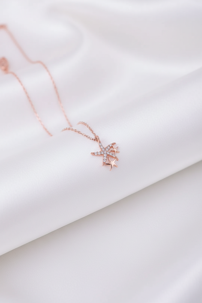 Beyaz saten arka planda rose gold denizyıldızı bileklik