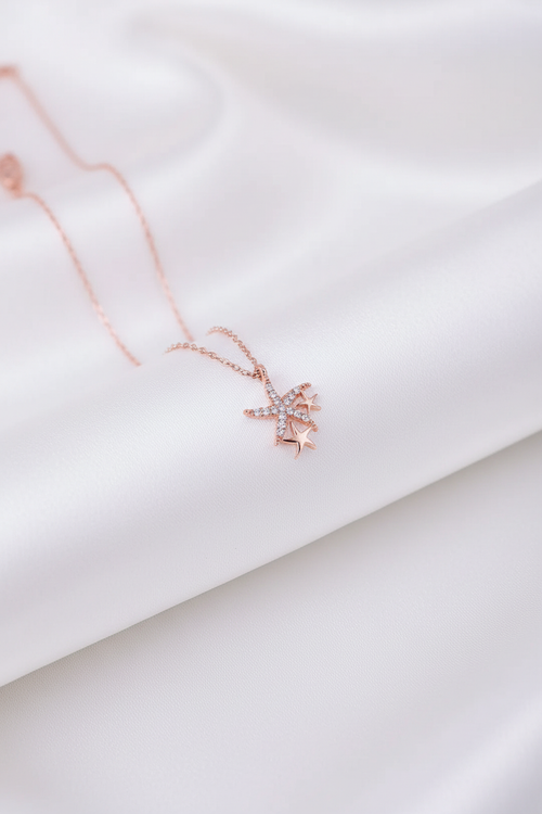 Beyaz saten arka planda rose gold denizyıldızı bileklik